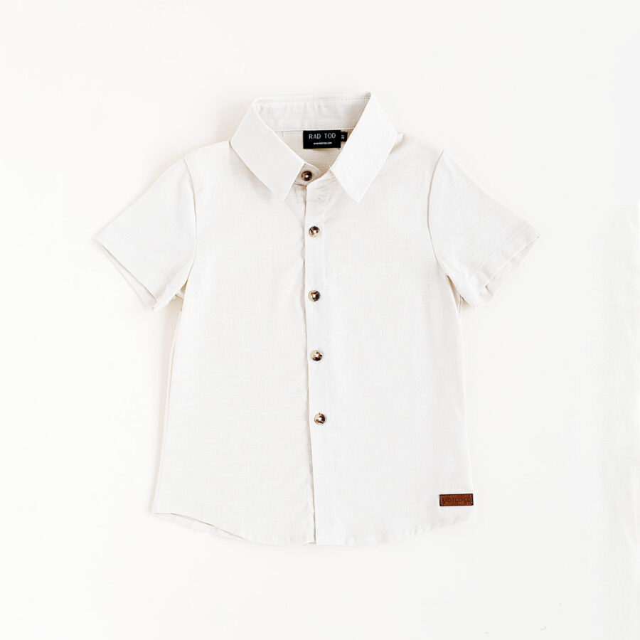 Bone colored button up shirt for kids. Looks stylish and has a leather patch at the bottom of the shirt