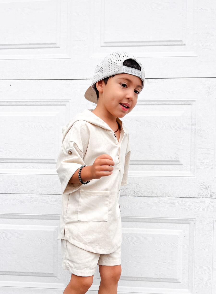 handsome boy wearing a stylish linen outfit and cool beige hat